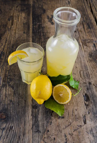Limonada orgánica fresca en un frasco con limones y hojas y un gla —  Fotos de Stock