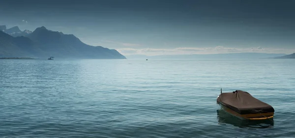 Panoramaberg-en meerlandschap met een enkele boot en kopieer ruimte — Stockfoto