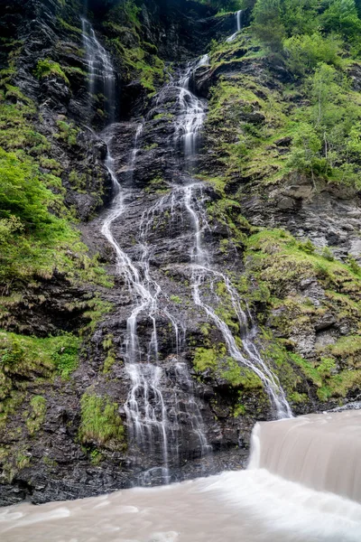 Panorama av högt pittoreskt vattenfall i frodig grönskogs mark — Stockfoto