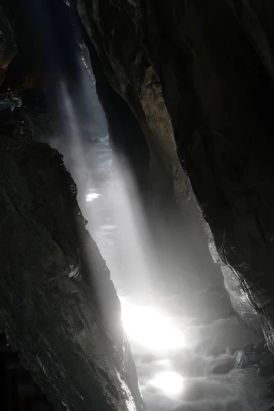 narrow slot canyon gorge with a wild creek and warm steam rising