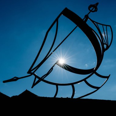 parlak mavi bulutsuz gökyüzü altında metal güneş kadranı