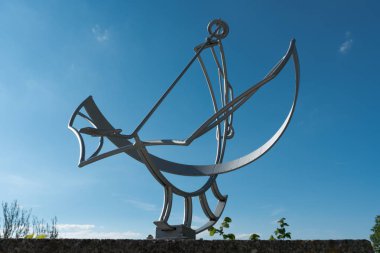 parlak mavi bulutsuz gökyüzü altında metal güneş kadranı