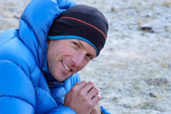 Primer plano de un alpinista masculino en una chaqueta de plumón gruesa looki — Foto de Stock