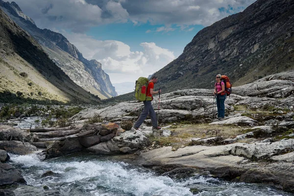 Hombre y mujer mochilero en los Andes del Perú cruzan un monte salvaje — Foto de Stock