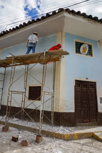 Lavoratori stomemason e pittore su un'impalcatura ristrutturare una casa — Foto Stock