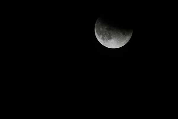 Vue rapprochée d'une éclipse lunaire partielle dans le ciel nocturne noir — Photo