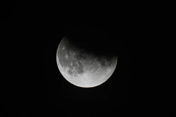 Vue rapprochée d'une éclipse lunaire partielle dans le ciel nocturne noir — Photo