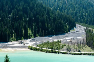 bir dağ Nehrinin ağzında ekskavatörler ve tekerlek yükleyiciler