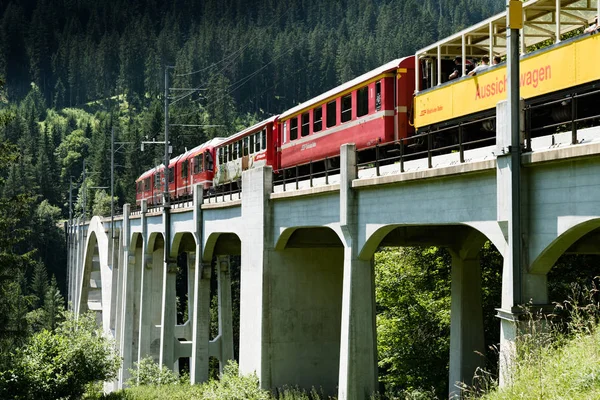 Tren de ancho estrecho cruza un largo viaducto a través de un profundo barranco i — Foto de Stock