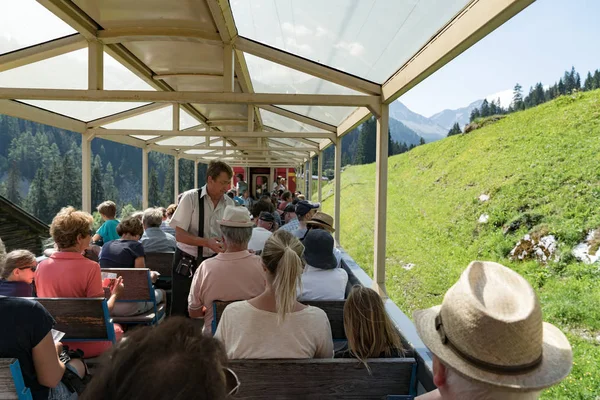 Tourists enjoy traveling in the open panorama carriage to Arosa — Stock Photo, Image