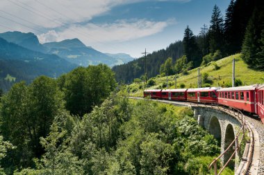kırmızı dar ölçer bir kıvrımlı St üzerinde bir taş köprü üzerinde traincrossing