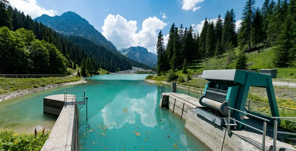 Fechaduras e herdeiro de uma represa em um lago de montanha de cor turquesa wat — Fotografia de Stock