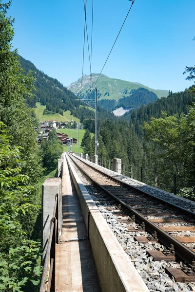 Vías del ferrocarril de vía estrecha conducen a través de un puente largo en el Swis — Foto de Stock