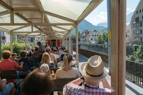 Tourists enjoy traveling in the open panorama train carriage from Chur — Stock Photo, Image