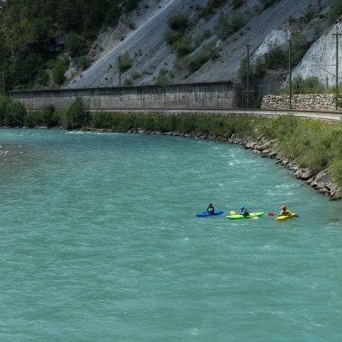 Üç kayakers mavi bir dağ nehirde kürek çekmeye