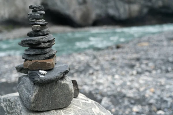 Rock cairn de perto com um rio de montanha turquesa no backg — Fotografia de Stock