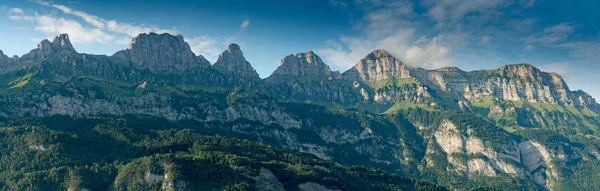 Paesaggio montano panoramico in Svizzera con numerose vette in calda luce serale — Foto Stock