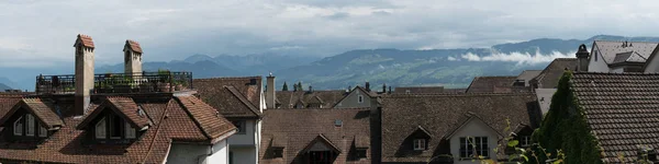 Arkasında dağ manzara ile Avrupa'da eski evler ve çatılar panorama görünümü — Stok fotoğraf