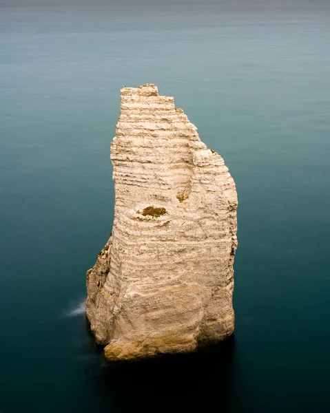 Roca aguja piedra caliza acantilado en un tranquilo océano azul oscuro —  Fotos de Stock