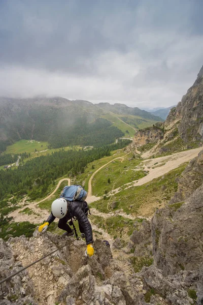 attractive young female mountain climber on a Via Ferrata in the