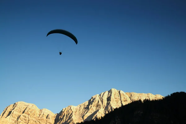 Silhouette of paraglider in Dolomite mountain landscape in eveni — Stock Photo, Image