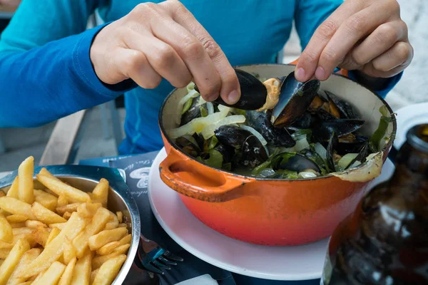 geleneksel midye ve patates kızartması yemek yiyen bir kadının elleri