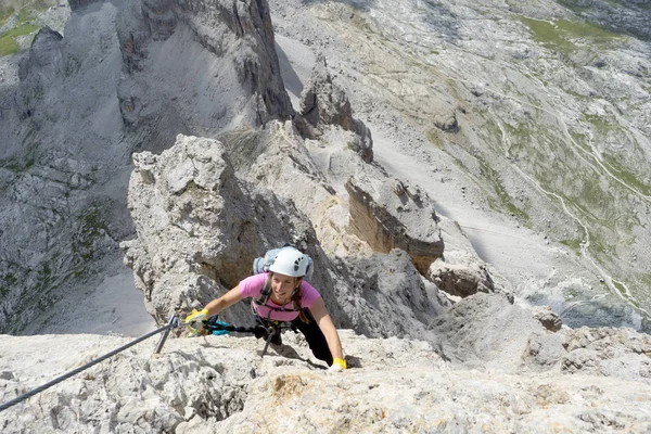 Pretty female climber in lilac shirt on a steep Via Ferrata in t — Stock Photo, Image