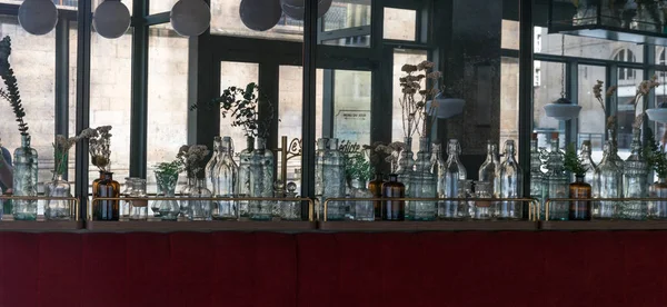 Dekoracyjne szklane butelki linii ściany w przytulnym małym Restauran — Zdjęcie stockowe