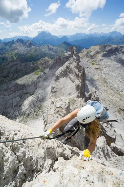 Attractive female climber on a steep Via Ferrata in the Italian — Stock Photo, Image