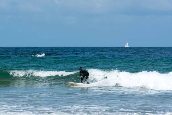 Un jeune garçon sportif surfant sur les vagues dans l'Atlantique sur la côte bretonne un jour d'été — Photo