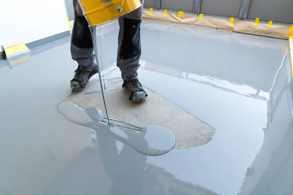 Byggnadsarbetare renoverar balkong golv och häller vattentätt — Stockfoto