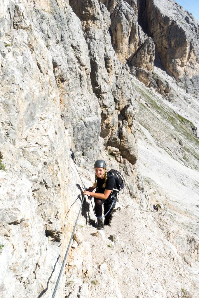 attractive blonde female mountain climber in the Dolomites of It