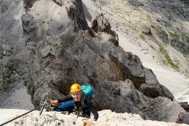I dik Via Ferrata üzerinde çekici sarışın kadın dağcı