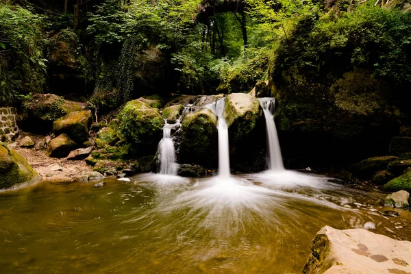 Idílico cascada pequeña en exuberante paisaje de bosque verde — Foto de Stock