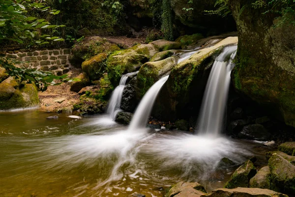 Idílico cascada pequeña en exuberante paisaje de bosque verde — Foto de Stock