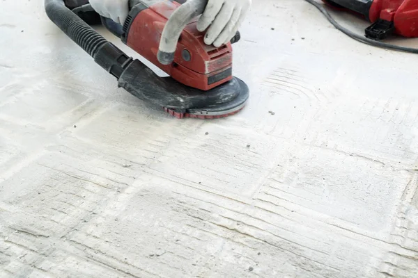 inşaat işçisi kiremit gl kaldırmak için bir beton öğütücü kullanır