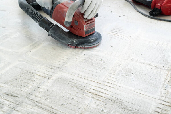 строитель использует бетонную мельницу для удаления плитки gl
