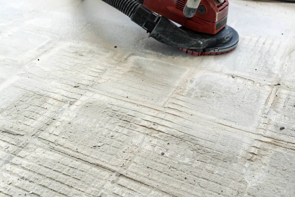 Будівельник використовує бетонну шліфувальну машину для видалення глянцю плитки — стокове фото