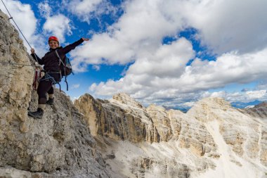 female mountain climber on a steep Via Ferrata in the Italian Do clipart