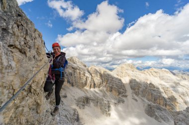 dik Via Ferrata üzerinde çekici sarışın kadın dağcı