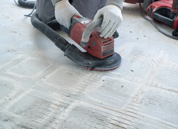 inşaat işçisi kiremit gl kaldırmak için bir beton öğütücü kullanır