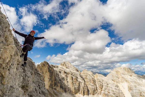 female mountain climber on a steep Via Ferrata in the Italian Do