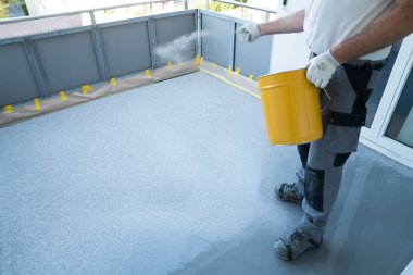 inşaat işçisi balkon zemini yeniler ve çip flo yayılır