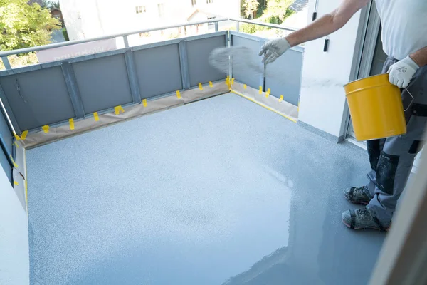Byggnadsarbetare renoverar balkong golv och sprider chip Flo — Stockfoto