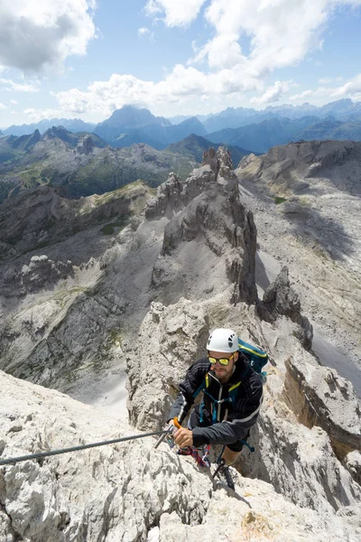 Joven alpinista masculino en una cara de roca empinada y expuesta cli — Foto de Stock