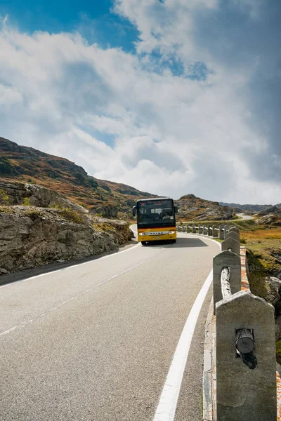 Autobús de correos suizo en una carretera de dos carriles que conduce a un alto control remoto y — Foto de Stock