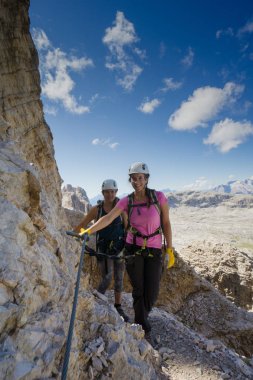 İtalyan Dolomitleri 'nde dik bir Via Ferrata' ya tırmanan çekici kadın tırmanışçılar.