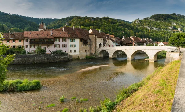 Doubs Nehri üzerindeki tarihi ve resimli İsviçre köyü Saint-Ursanne 'ın panoraması