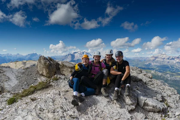 Four attractive women mountain climbers hug and smile on a mount — Stock Photo, Image