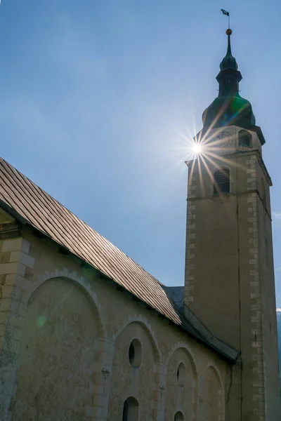 Vista horizontal de la iglesia protestante en el pueblo de Spluegen en los Alpes suizos con el sol brillante — Foto de Stock